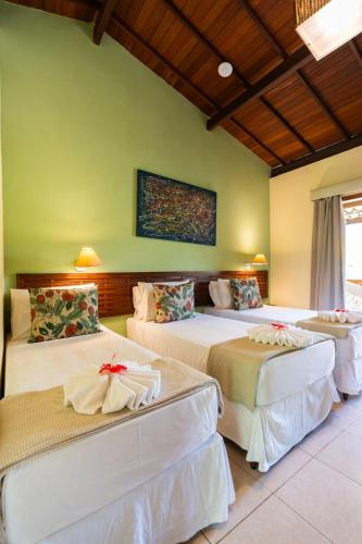 two beds in a room with green walls at Pousada Pedra Torta in Itacaré