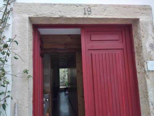 a red door in a building with a number sixteen at Casa de Condeixinha in Condeixa a Nova