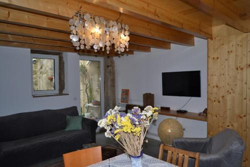 a living room with a couch and a table with flowers at Casa de Condeixinha in Condeixa a Nova