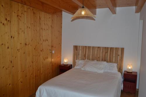 a bedroom with a white bed with two night stands at Casa de Condeixinha in Condeixa a Nova