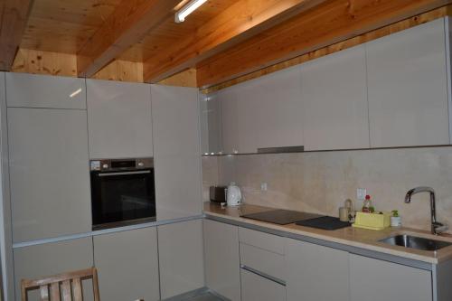 a kitchen with white cabinets and a sink at Casa de Condeixinha in Condeixa a Nova