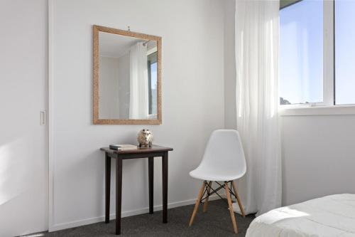 a bedroom with a mirror and a table and a chair at NEW - Farm House Near Town! in Gisborne