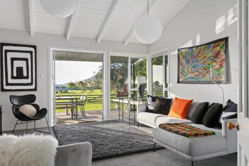 a living room with a couch and a table at NEW - Farm House Near Town! in Gisborne