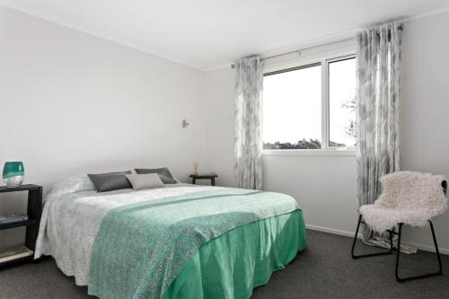 a white bedroom with a bed and a window at NEW - Farm House Near Town! in Gisborne