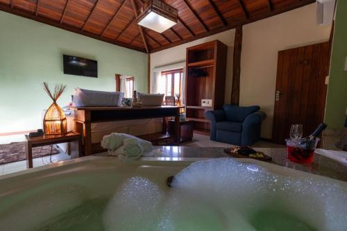 a bath tub in a living room with a piano at Pousada Pedra Torta in Itacaré