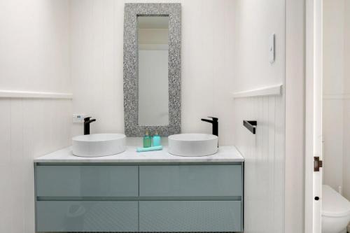 a bathroom with two sinks and a mirror at NEW - Farm House Near Town! in Gisborne