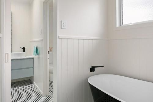 a bathroom with a white toilet and a sink at NEW - Farm House Near Town! in Gisborne