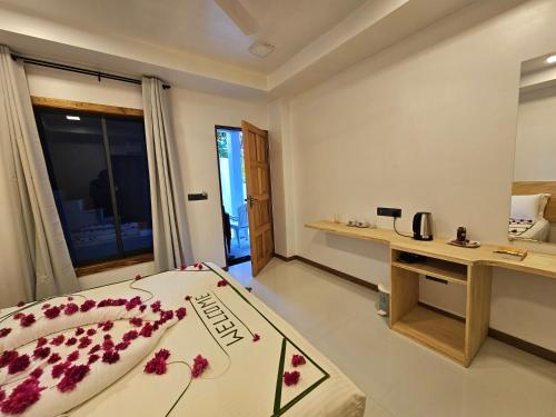 a room with a bed and a desk in it at Sunset Beach View in Dhangethi