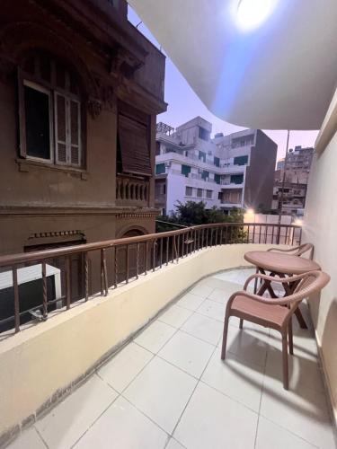 a balcony with a table and a bench on a building at Triple Garden Studios and apartments in Cairo