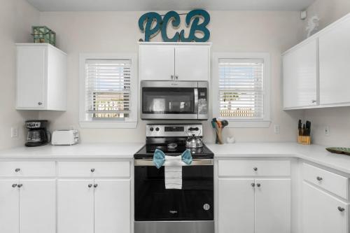 a kitchen with white cabinets and a black stove top oven at Bonita Retreat in Panama City Beach