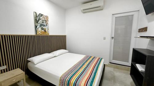 a small bedroom with a bed in a room at HOTEL LA FLORESTA in Arboletes