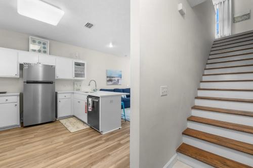 a kitchen with white cabinets and a staircase in a room at Bonita Retreat in Panama City Beach