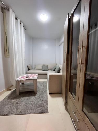 a living room with a couch and a table at Triple Garden Studios and apartments in Cairo