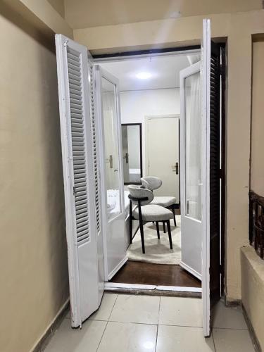 an open door into a room with a chair at Triple Garden Studios and apartments in Cairo