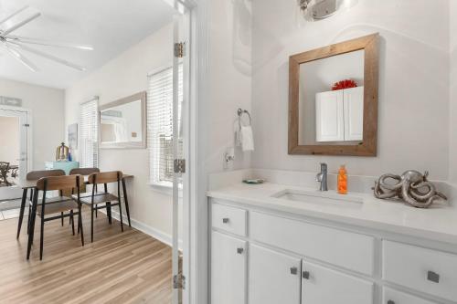 a white bathroom with a sink and a mirror at Bonita Retreat in Panama City Beach