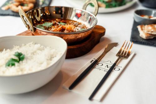 a table with a bowl of food and a bowl of rice at Domo Boutique Hotel Birmingham in Birmingham