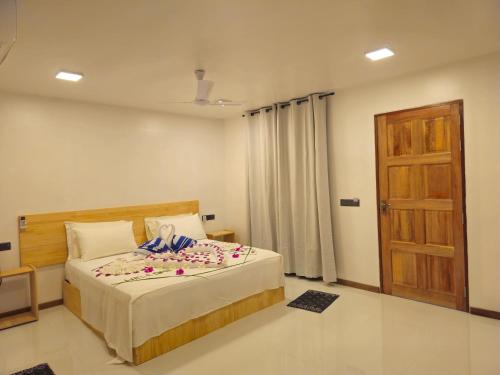 a bedroom with a bed with flowers on it at Sunset Beach View in Dhangethi