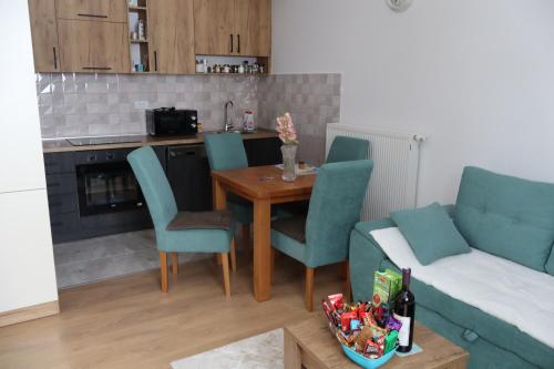 een woonkamer met een tafel, stoelen en een bank bij Vila Akva in Jahorina