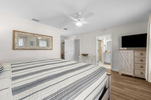 a bedroom with a large bed and a flat screen tv at Bonita Retreat in Panama City Beach