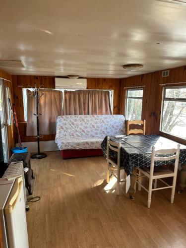 - une chambre avec un lit et une table dans l'établissement Bungalow 2 en bordure de lac accès jacuzzi, à Beaupouyet