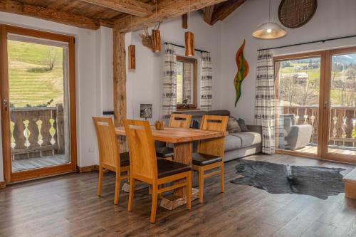 a dining room with a wooden table and chairs at Alpine Mountain Chalet in San Vigilio Di Marebbe