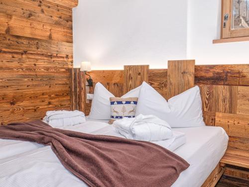 a bed with white sheets and towels on it at Alpine Mountain Chalet in San Vigilio Di Marebbe