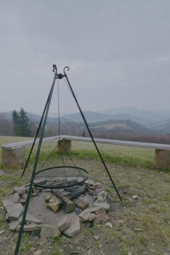 a fire pit with a swing in a field at Magiczne Wzgórze in Ustroń