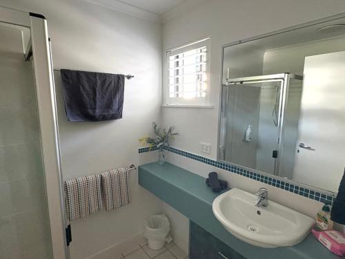 un bagno con lavandino, doccia e specchio di Spacious, 2 bedroom Townhouse in Noosaville Resort a Noosaville