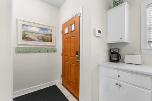 a kitchen with white walls and a wooden door at Bonita Retreat in Panama City Beach
