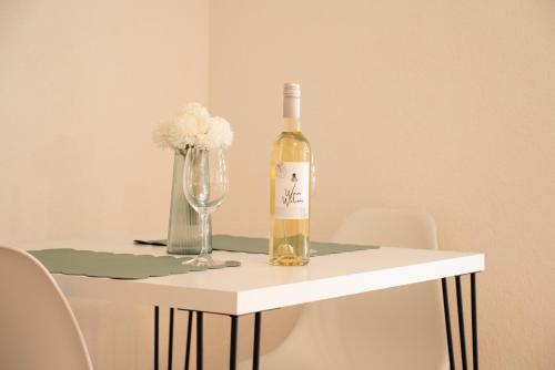 una bottiglia di vino appoggiata su un tavolo con un bicchiere di Iris Apartments a Ohrid