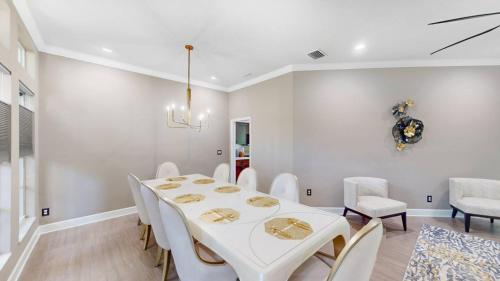 a dining room with a white table and white chairs at The Riverview Estates Sauna And Heated Pool in Riverview