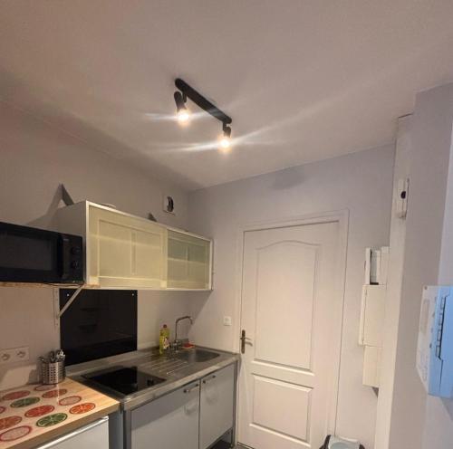 une cuisine avec des armoires blanches et un four à plaques de cuisson dans l'établissement Appartment 4 pers IDEAL voyageur located in incontournable rue faidherbe in front of GARE LILLE FLANDRES, à Lille