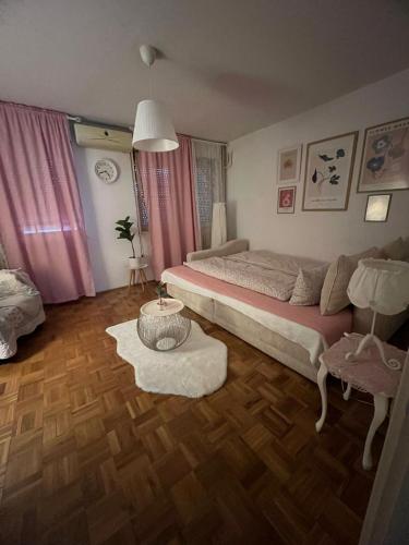 a bedroom with a bed and a table in it at Apartman Kosa in Bežanija