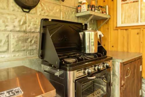 a kitchen with an oven with a stove top at Glamping at Deer Camp in Dunlap