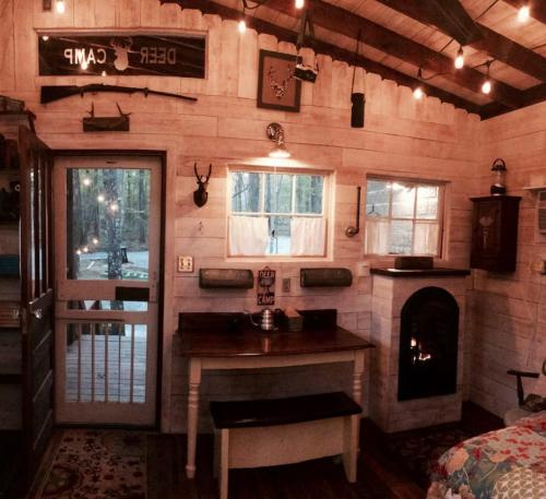 a room with a kitchen and a fireplace in a house at Glamping at Deer Camp in Dunlap