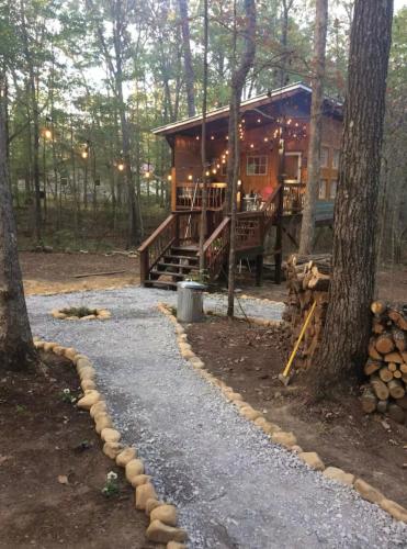 a log cabin in the woods with a path leading to it at Glamping at Deer Camp in Dunlap
