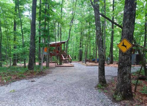 a playground in the woods with a sign on a tree at Glamping at Deer Camp in Dunlap