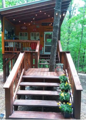 a deck with stairs leading to a tree house at Glamping at Deer Camp in Dunlap