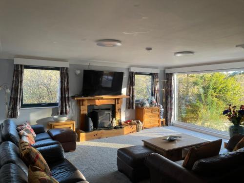 a living room with a couch and a fireplace at 5 bed house near Oban in Oban