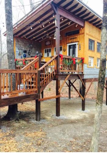 a deck in front of a house with flowers on it at Glamping at Deer Camp in Dunlap