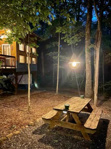 a wooden picnic table with a light on it at Glamping at Deer Camp in Dunlap