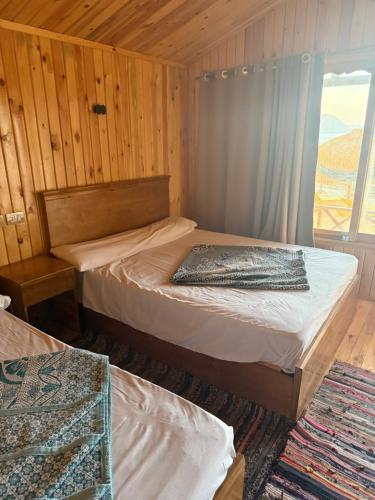 a room with two beds and a window in it at Love beach camp in Taba