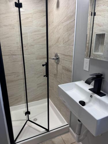 a shower with a glass door next to a white sink at Beautiful home with mountain top views with an EV and NEMA connection!! in Poughkeepsie