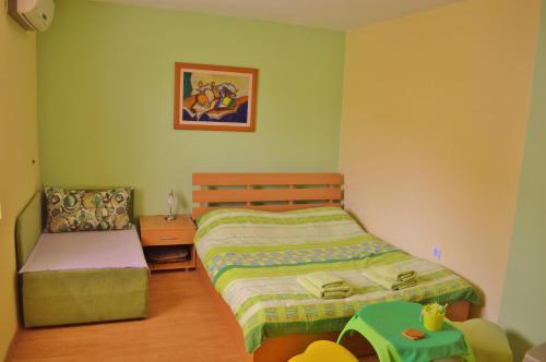 a small bedroom with a bed and a chair at Villa Ohrid in Ohrid