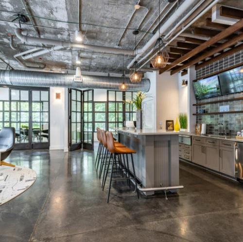 an industrial kitchen with a bar and stools at Atlanta Beltline Luxury Double Suite in Atlanta