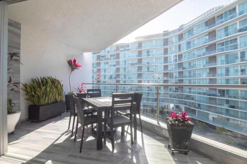 a balcony with a table and chairs and a large building at Suites at Aria Luxury Double Suite on the Pacific Coast in Nuevo Vallarta 