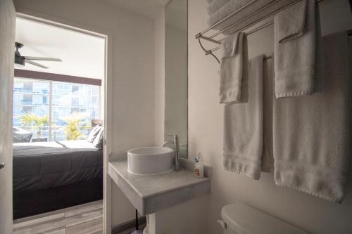 a bathroom with a sink and a mirror and a bed at Suites at Aria Luxury Double Suite on the Pacific Coast in Nuevo Vallarta 