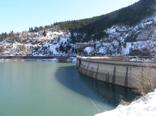 a dam on a river with snow on a mountain at Hotel Antigoni in Neochori