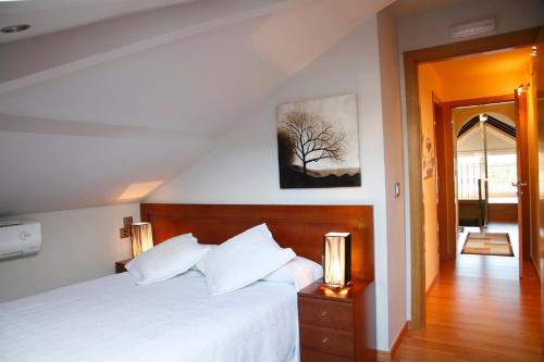 a bedroom with a bed and a tree picture on the wall at Hotel Casa de Caldelas in Castro Caldelas