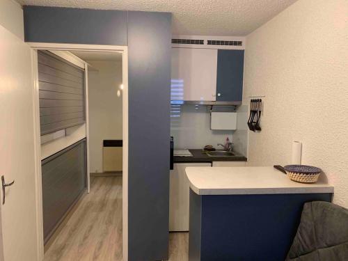 - une petite cuisine avec des placards bleus et un comptoir dans l'établissement Joli studio Cauterets, à Cauterets